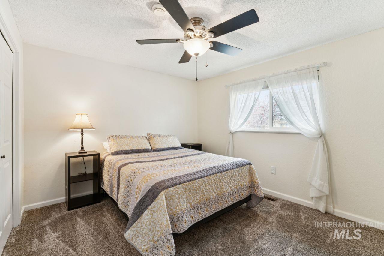 4093 North Marylebone Way Boise, ID 83713 - Photo 24 of 48 Bedroom with a closet, dark carpet, a ceiling fan, and a textured ceiling