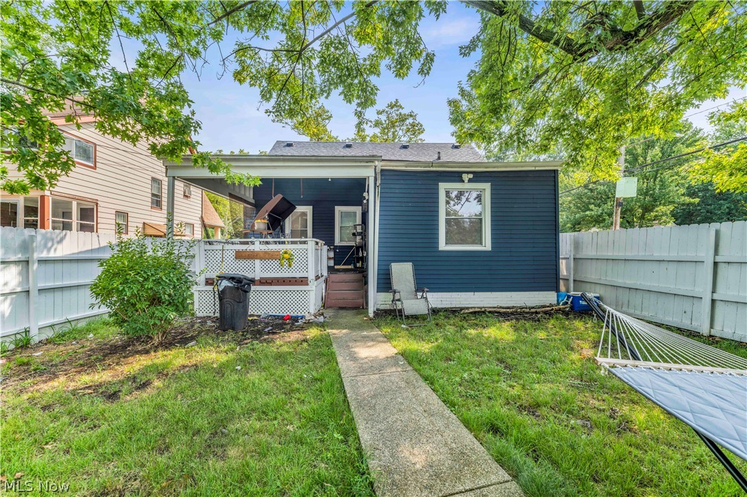 3731 Lowell Road Cleveland Heights, OH 44121 - Photo 29 of 29 Charming home featuring a dark blue exterior with modern siding, welcoming covered front porch with steps, mature landscaping with established trees providing natural shade, fenced yard with manicured lawn, and concrete walkway leading to the entrance