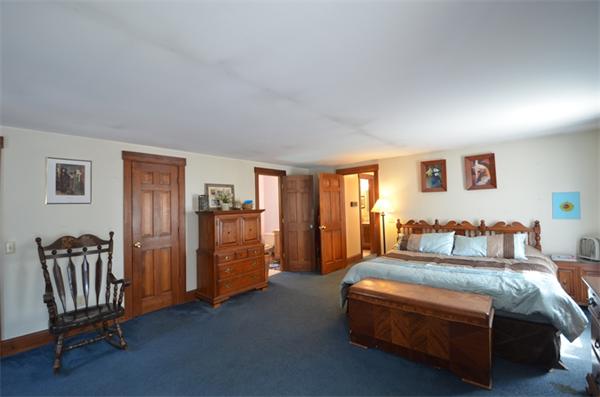 64 North Sturbridge Road Charlton, MA 01507 - Photo 16 of 30 a spacious bedroom with a bed and a chair