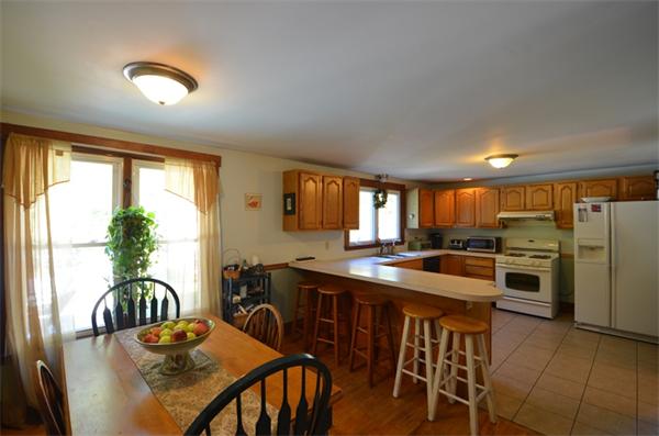 64 North Sturbridge Road Charlton, MA 01507 - Photo 6 of 30 a kitchen with stainless steel appliances granite countertop a stove a refrigerator a dining table and chairs with wooden floor