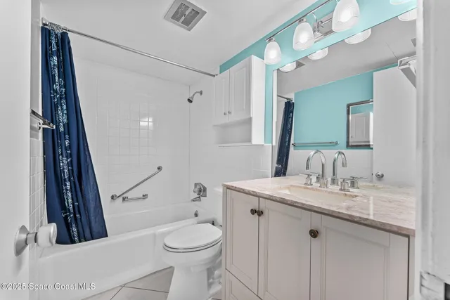 wooden floor in a hall with an entryway and a chandelier