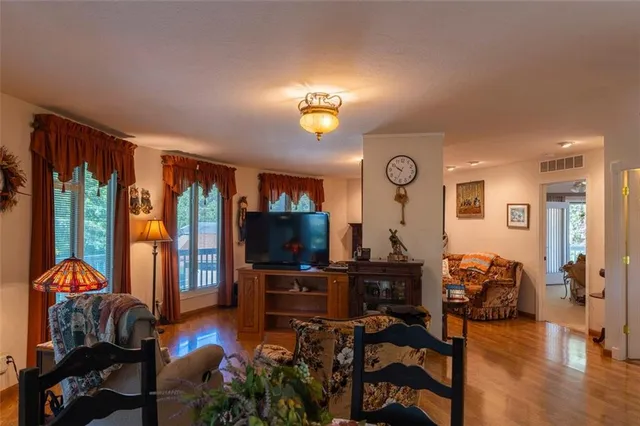 a living room with furniture a flat screen tv and a large window