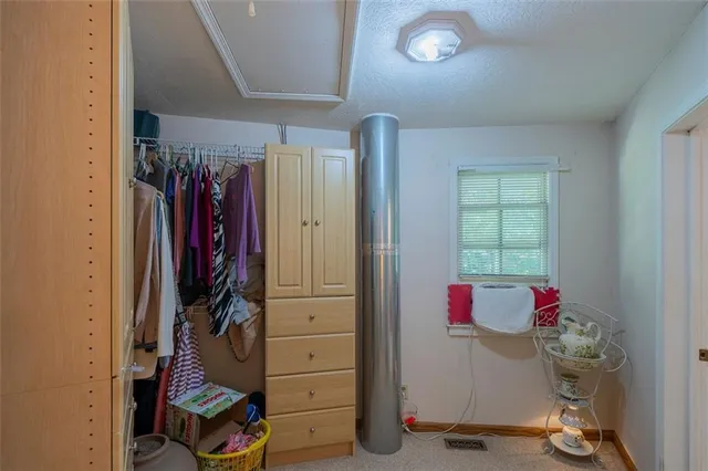a view of walk in closet with clothes