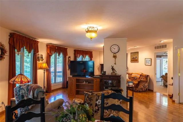 a living room with furniture a flat screen tv and a large window