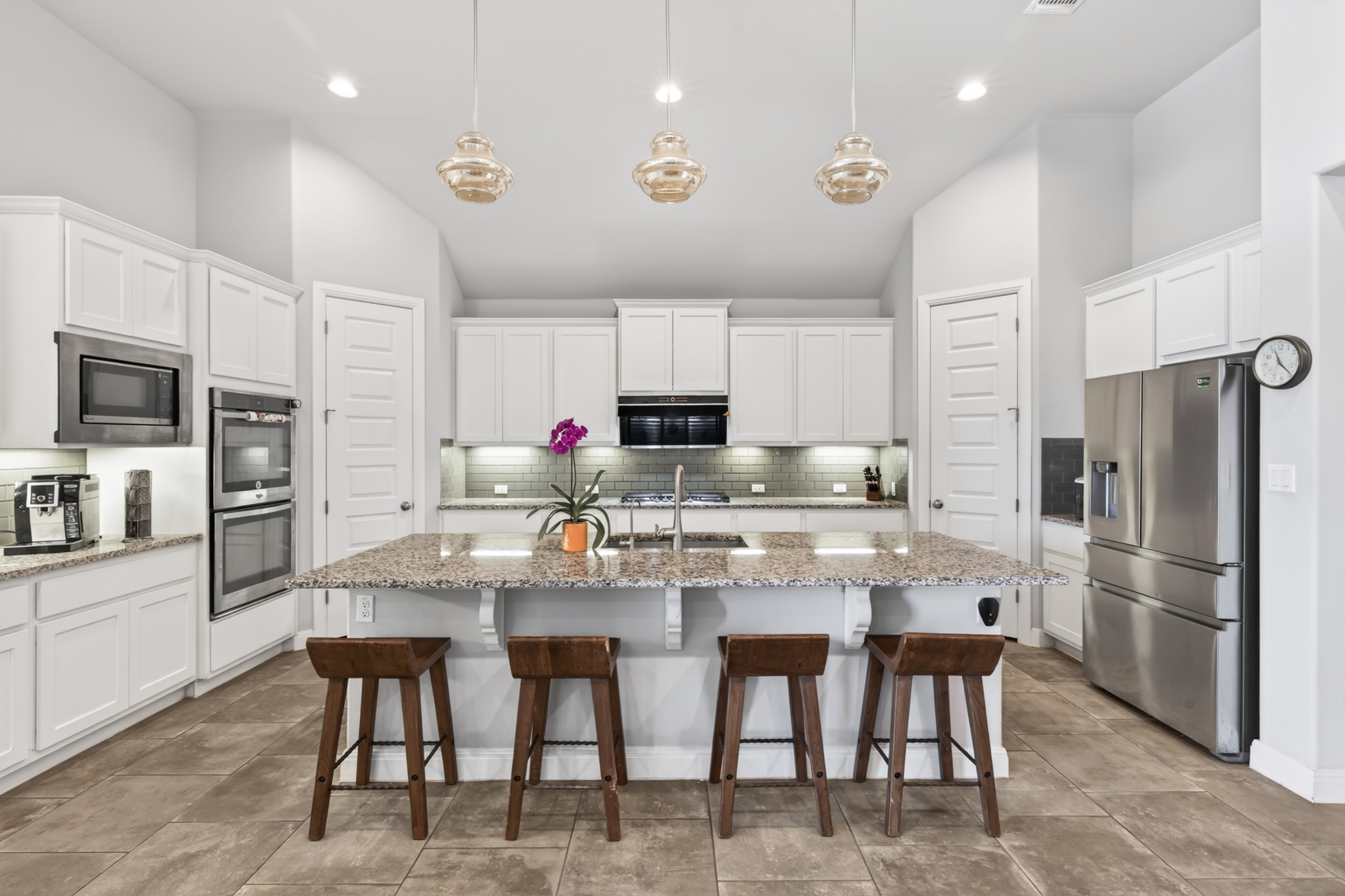 4105 Haight Street Round Rock, TX 78681 - Photo 16 of 40 Spacious kitchen featuring an expansive center island with seating, pendant lighting, stainless steel appliances, white cabinetry, and tile flooring
