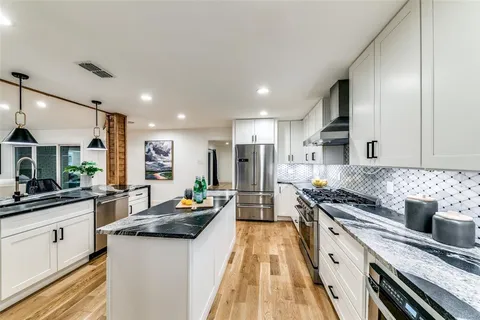 a kitchen with stainless steel appliances granite countertop a sink stove and refrigerator