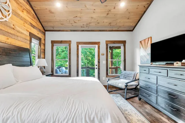a bedroom with a bed and flat screen tv