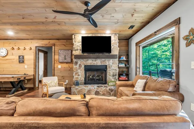 a living room with furniture a flat screen tv and a fireplace