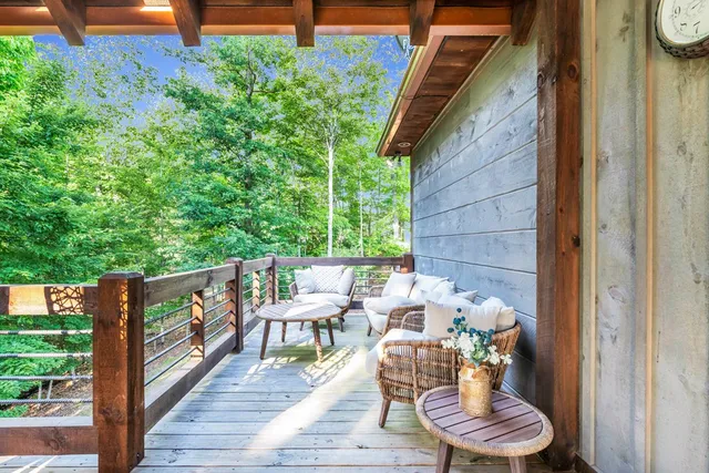 a view of a balcony with chairs and wooden floor