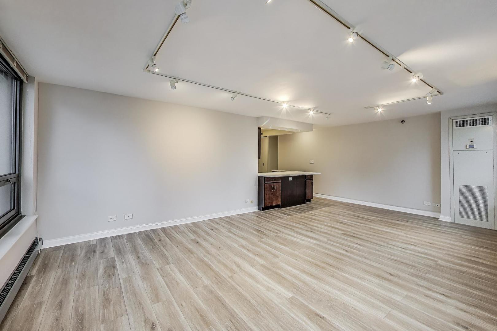 440 North Wabash Avenue, Unit 1605 Chicago, IL 60611 - Photo 15 of 53 an empty room with wooden floor kitchen view and a window