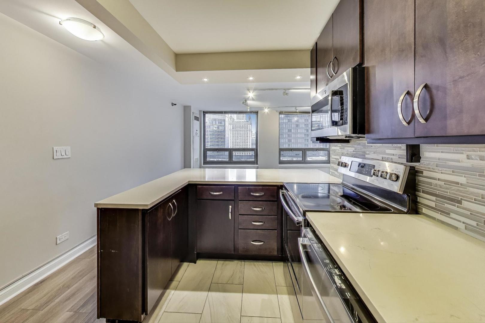 440 North Wabash Avenue, Unit 1605 Chicago, IL 60611 - Photo 20 of 53 a kitchen with wooden cabinets a sink and a stove