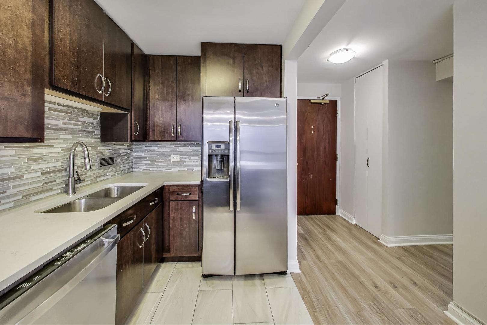440 North Wabash Avenue, Unit 1605 Chicago, IL 60611 - Photo 21 of 53 a kitchen with stainless steel appliances granite countertop a refrigerator a sink and wooden cabinets