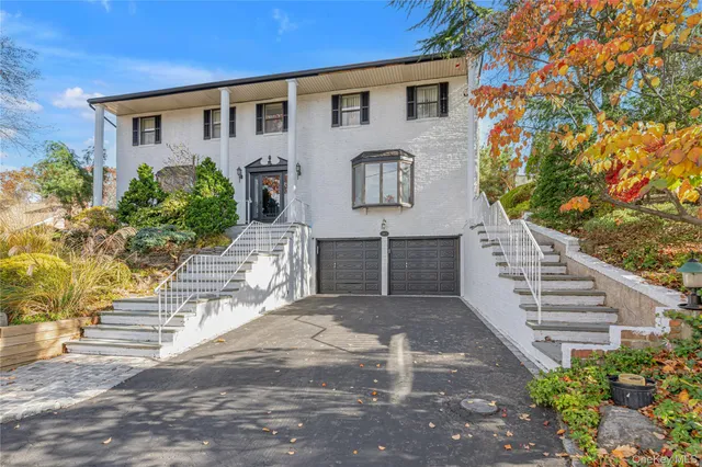 a front view of a house with a yard and trees
