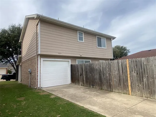 a front view of house with backyard and trees