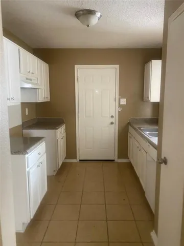 a kitchen with a sink a stove and cabinets