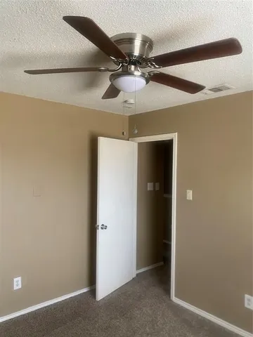 en view of a livingroom with a ceiling fan and window