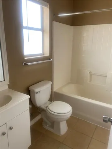 a white toilet sitting next to a bath tub