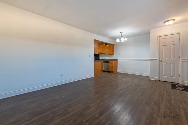 an empty room with wooden floor sink and cabinet
