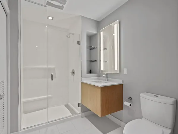 a bathroom with a granite countertop sink toilet and shower
