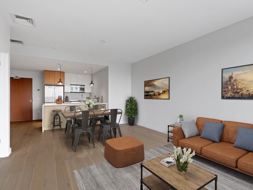 375 Canal Street, Unit 812 Somerville, MA 02145 - Photo 4 of 20 a living room with furniture kitchen view and a dining table