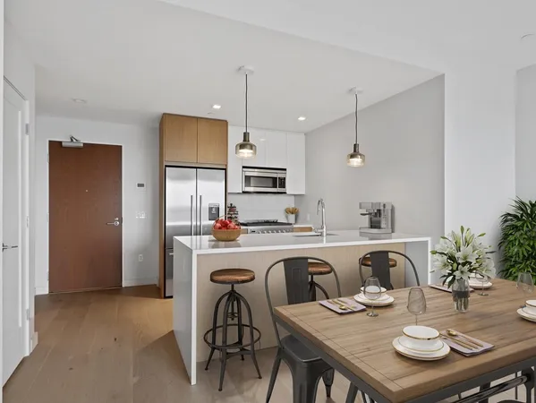 a kitchen with stainless steel appliances granite countertop a dining table and chairs