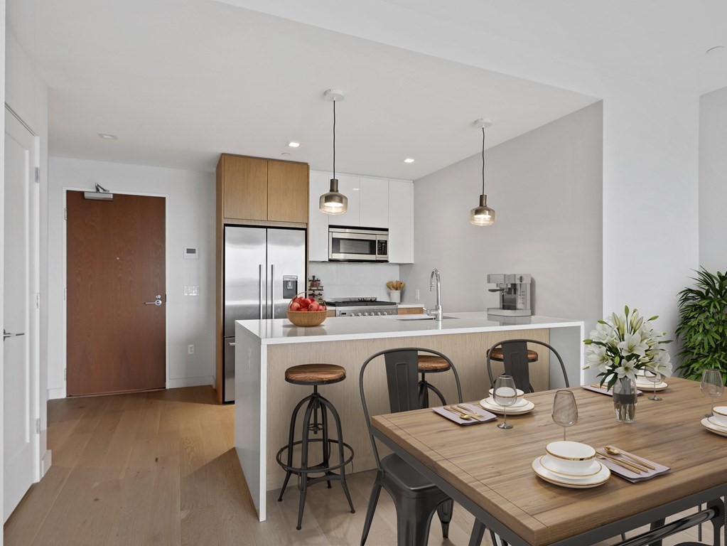 375 Canal Street, Unit 812 Somerville, MA 02145 - Photo 5 of 20 a kitchen with stainless steel appliances granite countertop a dining table and chairs