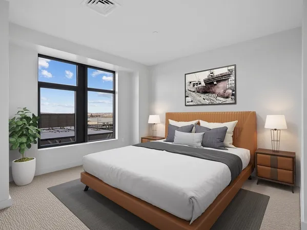 a large bed sitting in a bedroom next to a window