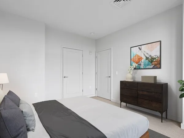 a bedroom with a bed and paintings on the wall