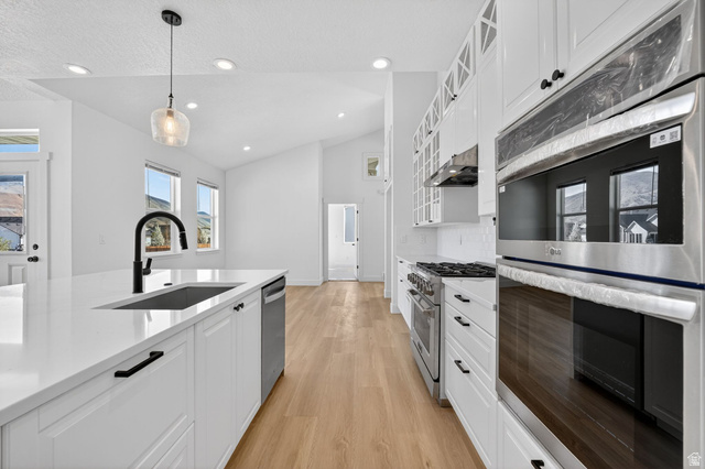 572 West 500th Street North Mapleton, UT 84664 - Photo 10 of 46 Kitchen with stainless steel appliances, white cabinets, glass fronted cabinets, light wood-style flooring, and lofted ceiling