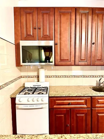 a kitchen with granite countertop cabinets stove and microwave