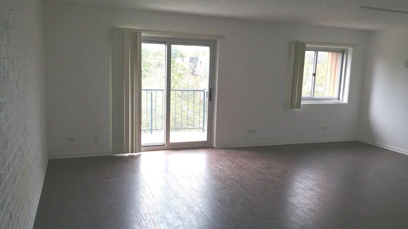 3220 Sanders Road, Unit 3B Northbrook, IL 60062 - Photo 3 of 11 an empty room with wooden floor and windows
