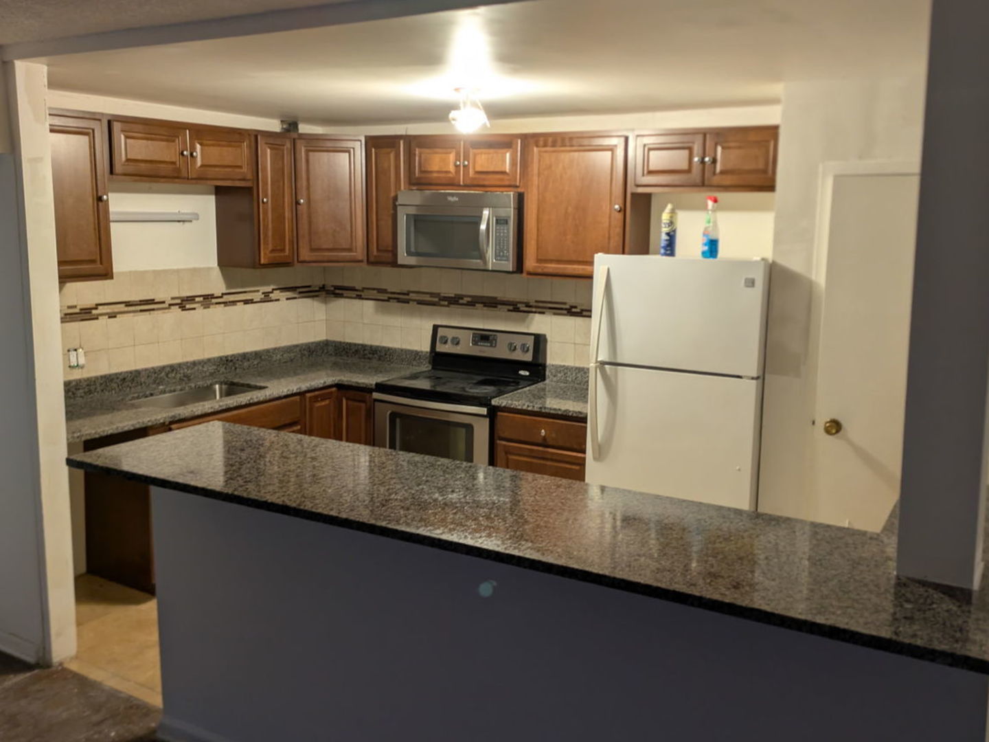 3220 Sanders Road, Unit 3B Northbrook, IL 60062 - Photo 4 of 11 a kitchen with granite countertop a sink a stove and refrigerator