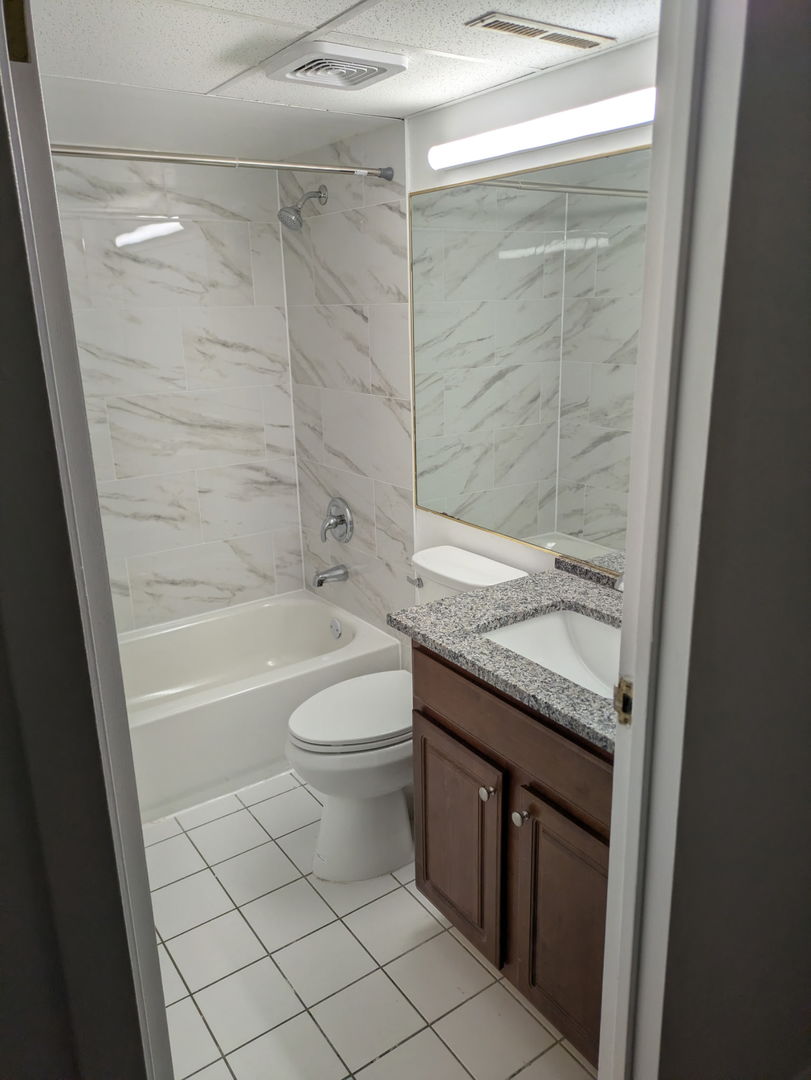 3220 Sanders Road, Unit 3B Northbrook, IL 60062 - Photo 7 of 11 a bathroom with a granite countertop sink a toilet and bathtub