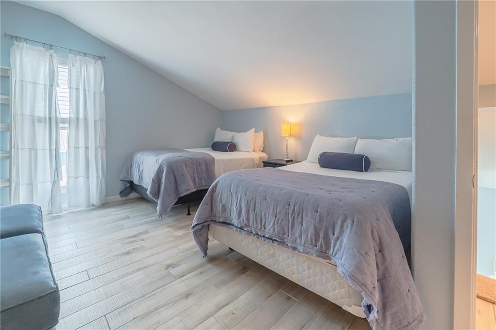 2292 North Fulton Beach Road, Unit 405 Rockport, TX 78382 - Photo 12 of 40 a bedroom with two beds and large window
