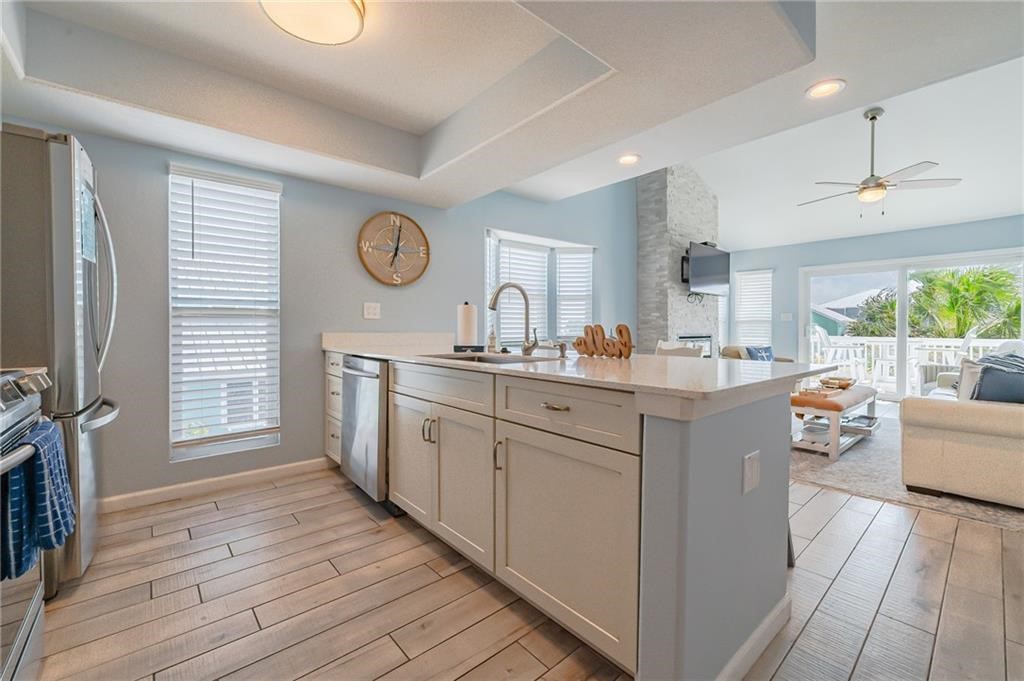2292 North Fulton Beach Road, Unit 405 Rockport, TX 78382 - Photo 9 of 40 a open kitchen with white cabinets and wooden floor