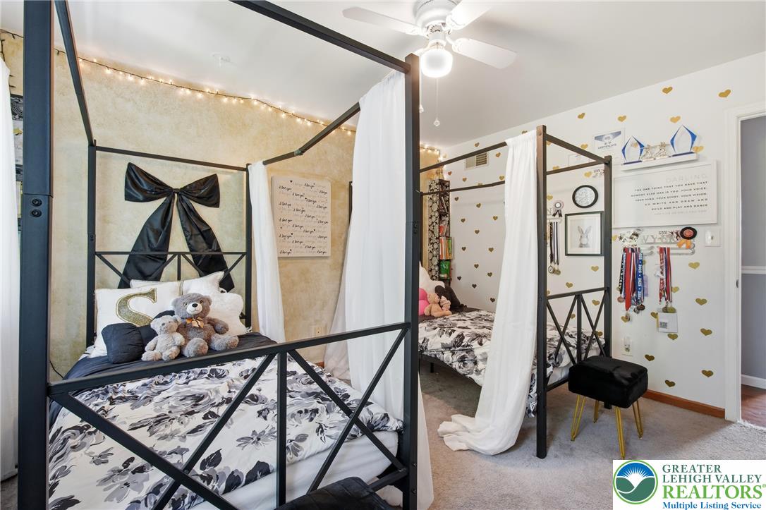 890 Lahr Road Nazareth, PA 18064 - Photo 24 of 71 Two elegant four-poster beds anchor this cheerful room, bathed in soft illumination from string lights.