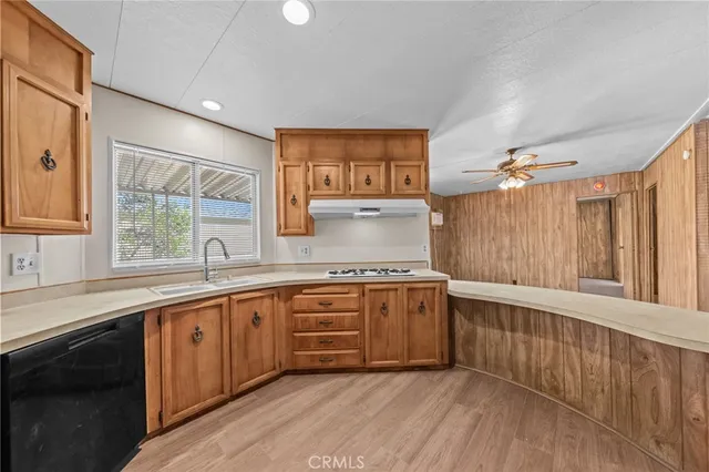 a large kitchen with kitchen island granite countertop wooden floors a sink stainless steel appliances and cabinets