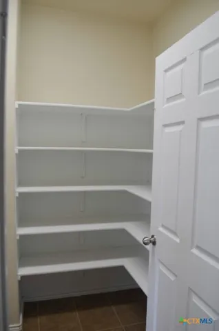 a view of an empty room with a fireplace and a window