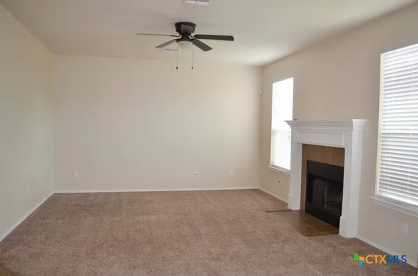 a view of an empty room with a fireplace and a window