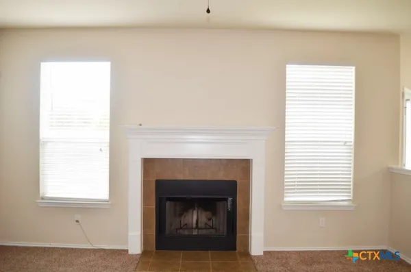 a living room with a fireplace and windows