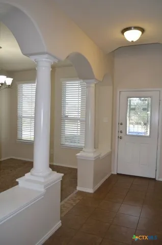 a view of a small space with chandelier fan and a window