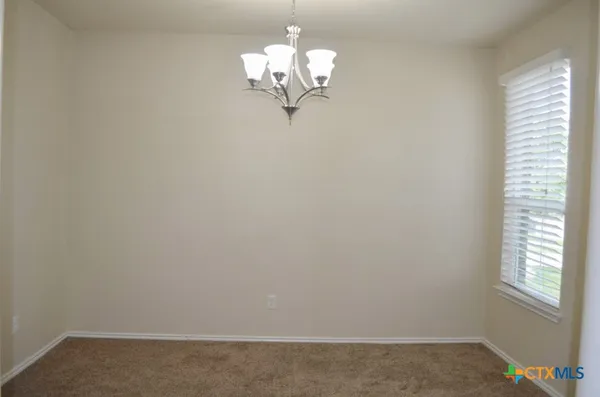 a view of a small space with chandelier fan and a window