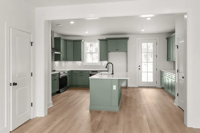 a kitchen with a sink and wooden floor