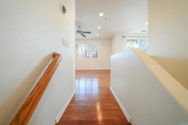 a view of a hallway with wooden floor and staircase