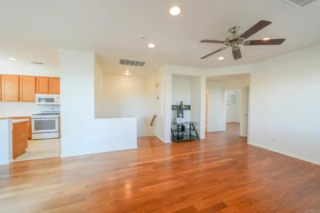 a view of empty room with wooden floor and window