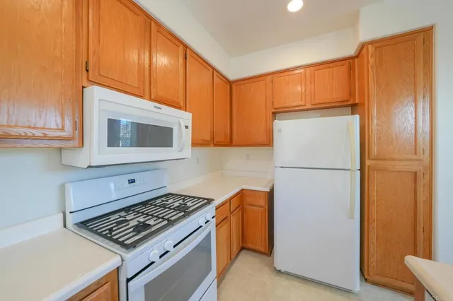 a kitchen with a refrigerator and a stove top oven