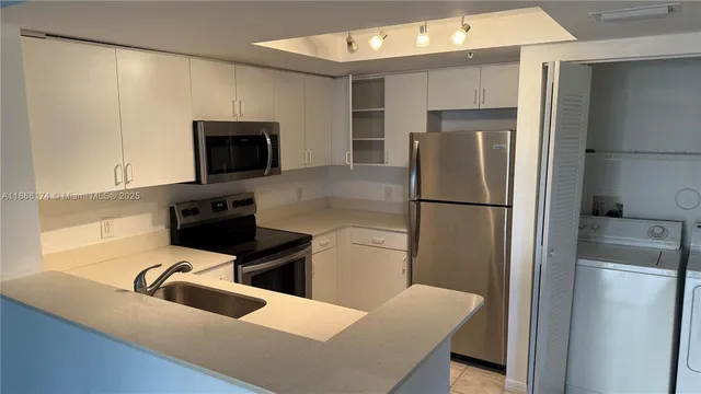 a kitchen with a refrigerator a microwave a sink and cabinets