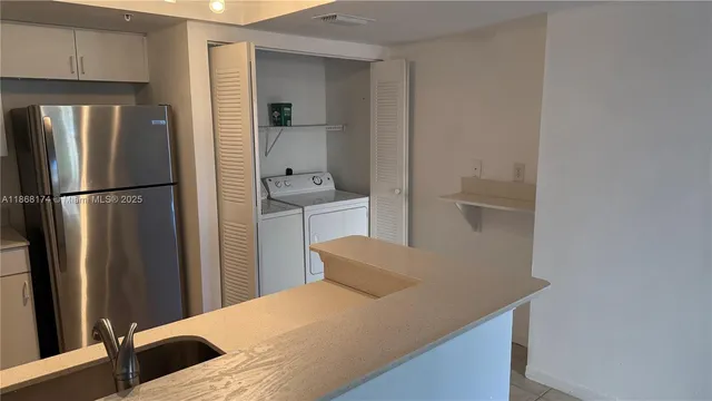 a kitchen with stainless steel appliances a refrigerator and wooden floor