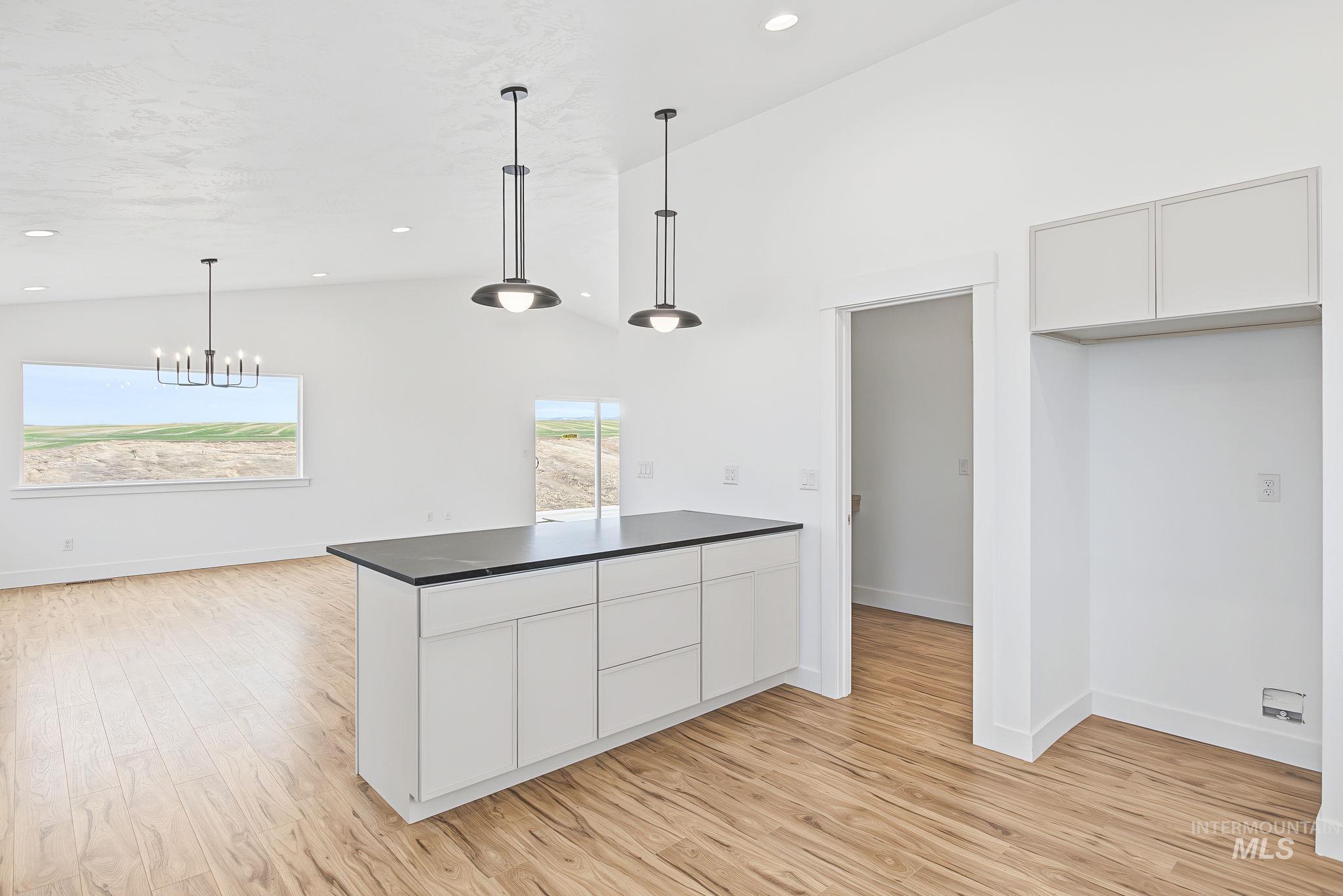 3217 Hidden Valley Loop Lewiston, ID 83501 - Photo 21 of 50 White built-in shelving, hanging rods, wood-finish flooring, a wood vanity with a vessel sink, and a framed window