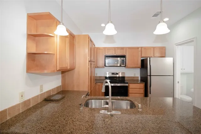 a kitchen with stainless steel appliances granite countertop a sink refrigerator and microwave